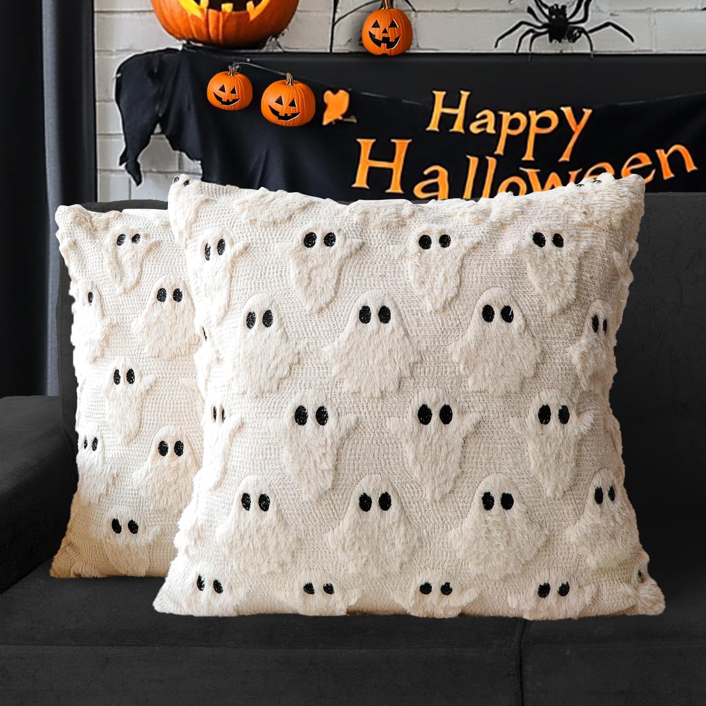 Cream pillow covers with plush little ghosts on a dark couch.