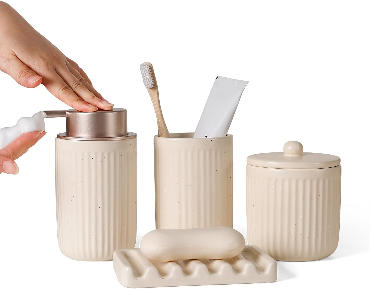 Four-piece cream ribbed ceramic bathroom set: soap dispenser, toothbrush cup, lidded canister, and soap dish.