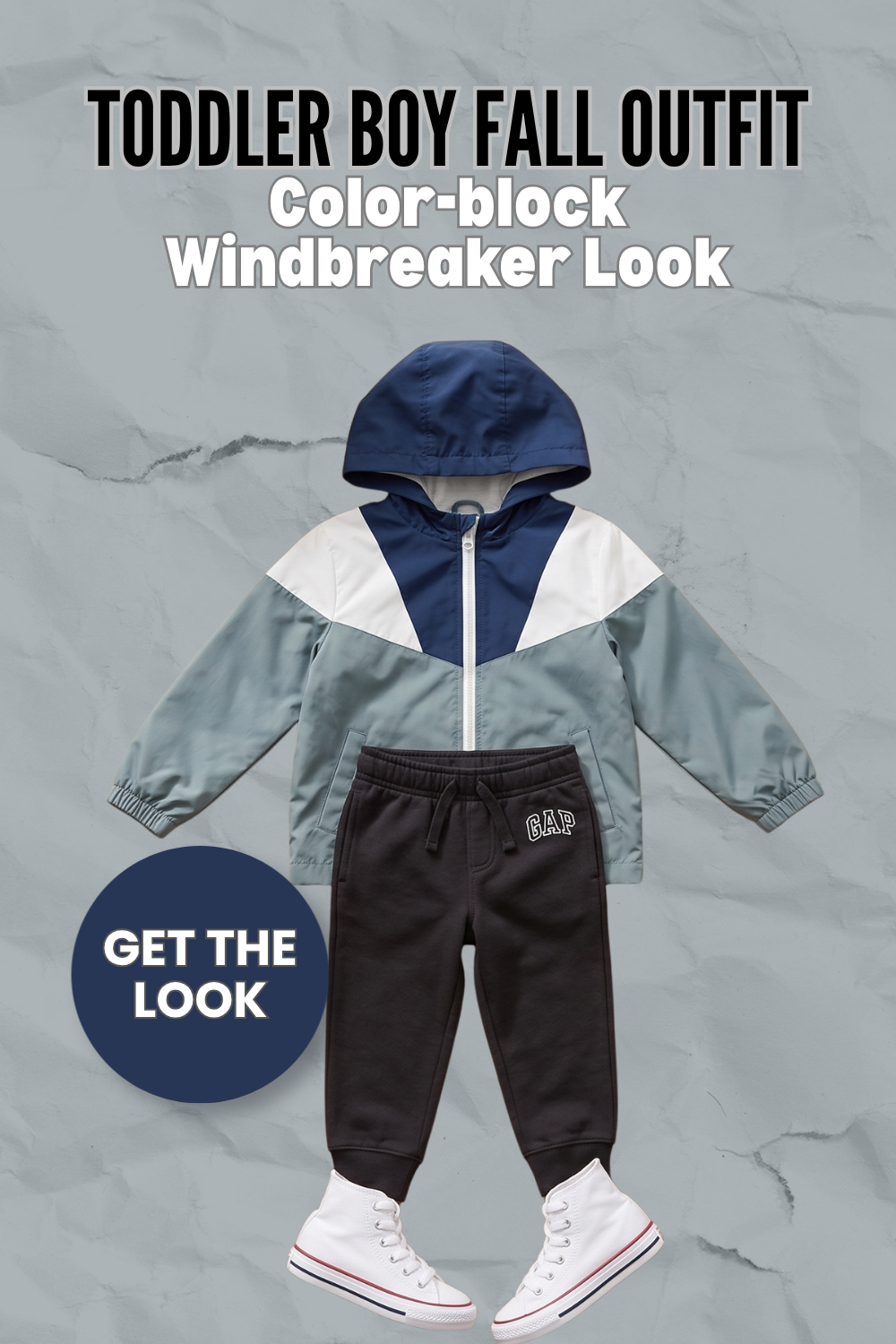 Pin graphic titled 'Toddler Boy Fall Outfit: Color-block Windbreaker Look' showing a sage, navy, and cream hooded windbreaker, black GAP joggers, and white high-top sneakers.