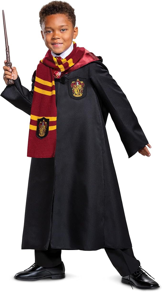 Child wearing a black wizard school robe with a red lining, house crest, striped scarf, and holding a wand.
