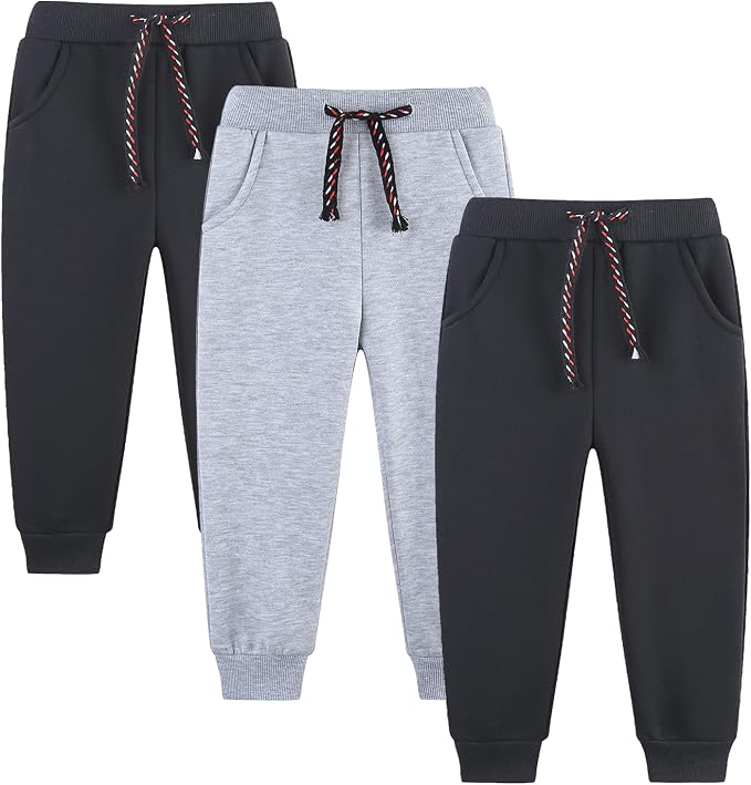 Three pairs of toddler fleece joggers in charcoal, heather grey, and black, each with a drawstring waist and side pockets.