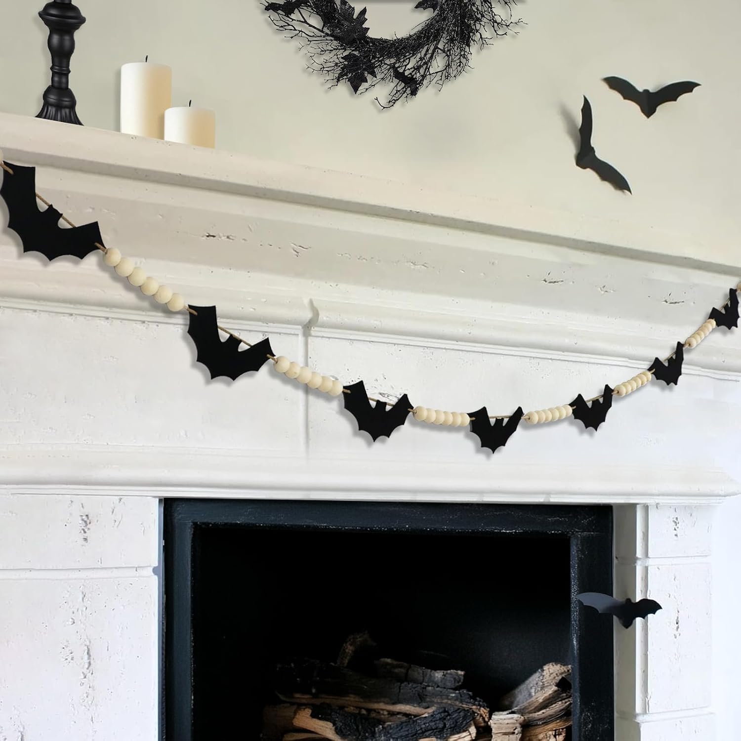 Felt bat and wooden bead garland draped across a white fireplace mantel.