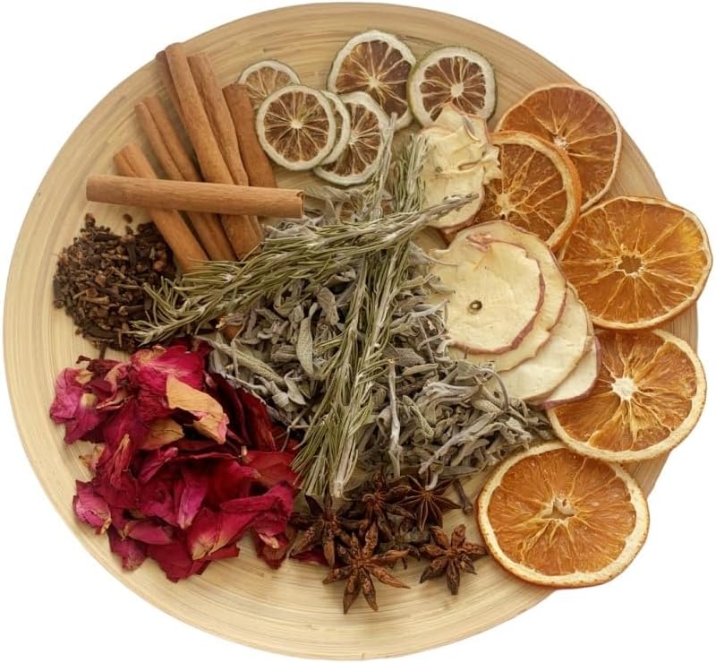 Wooden plate holding cinnamon sticks, cloves, dried orange and lime slices, rosemary, star anise, and rose petals.