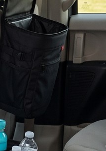 Black leak-proof car trash can hanging from the back of a front seat headrest.
