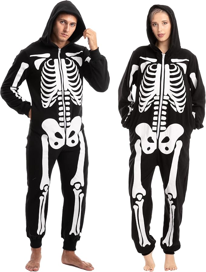 Two adults wearing matching black hooded skeleton-print onesies with white bone graphics.