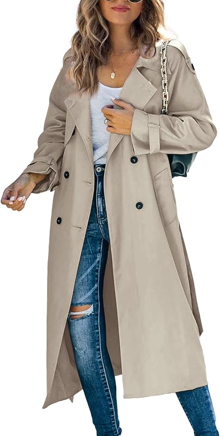Woman wearing a long beige double-breasted belted trench coat over a white tee and jeans.