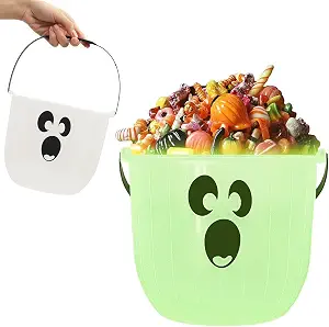 Green glow-in-the-dark ghost candy bucket filled with Halloween candy.