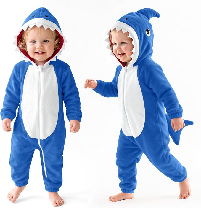 Toddler wearing a blue fleece shark onesie with a white belly and hooded fin.
